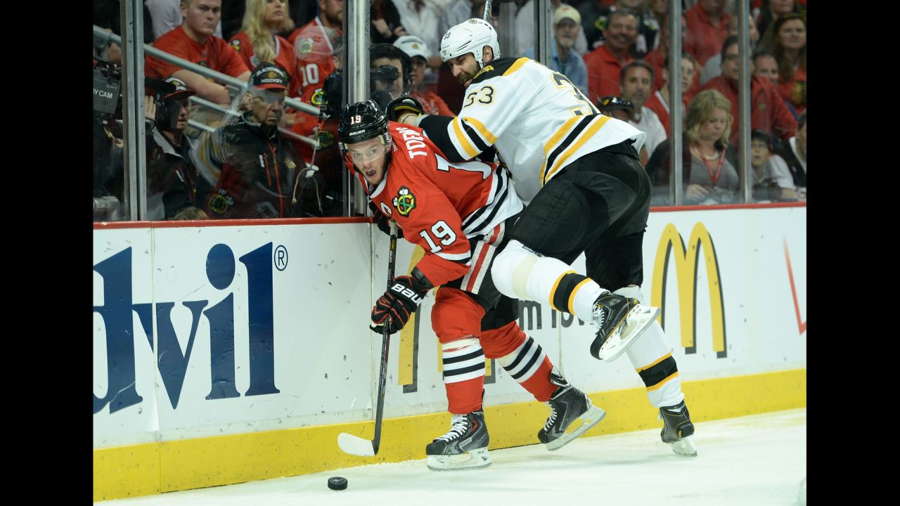  Zdeno Chara of the Boston Bruins checks Jonathan Toews of the Chicago Blackhawks.