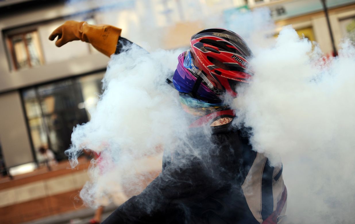 A protester throws a tear gas canister back at riot police during clashes near Taksim Square on June 16.