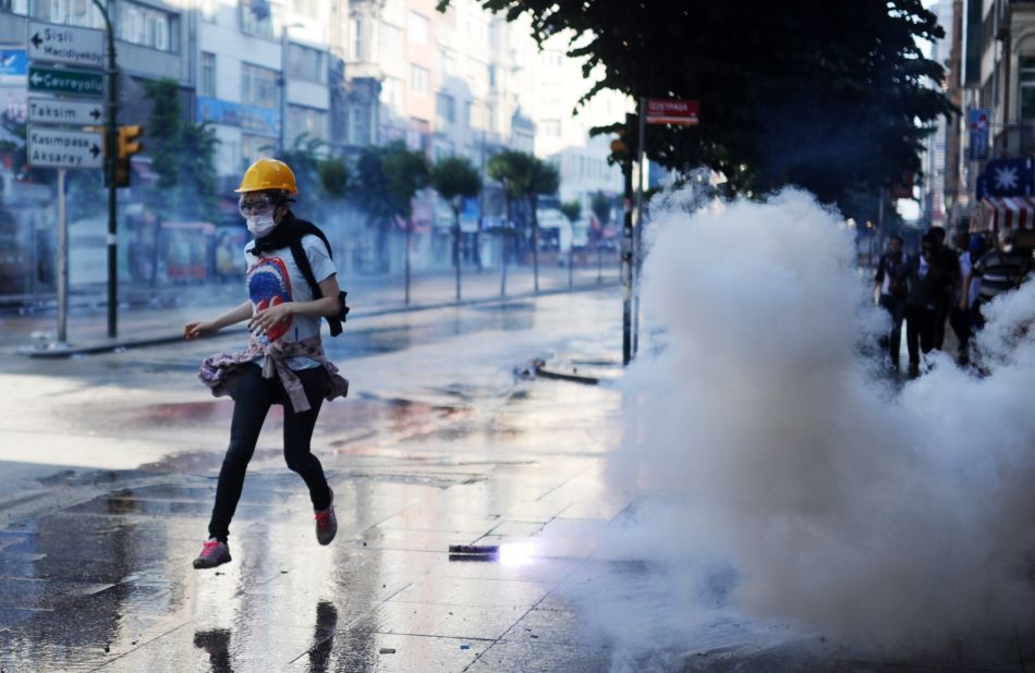 A protester runs during clashes between riot police and demonstrators in the streets adjacent to Taksim Square in Istanbul on Sunday, June 16.  