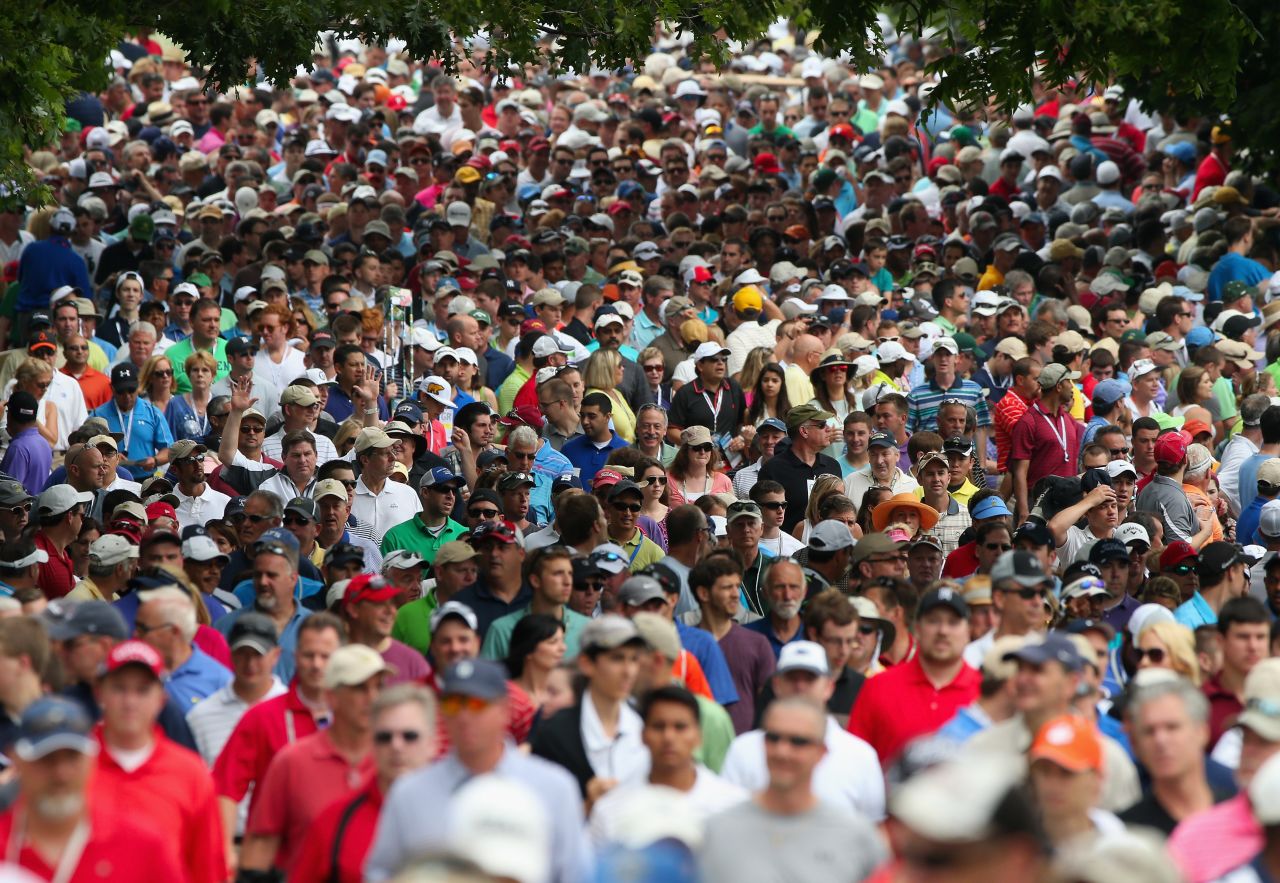 A gallery of fans follows Tiger Woods and Matt Bettencourt of the United States near the second hole during the final round on June 16.