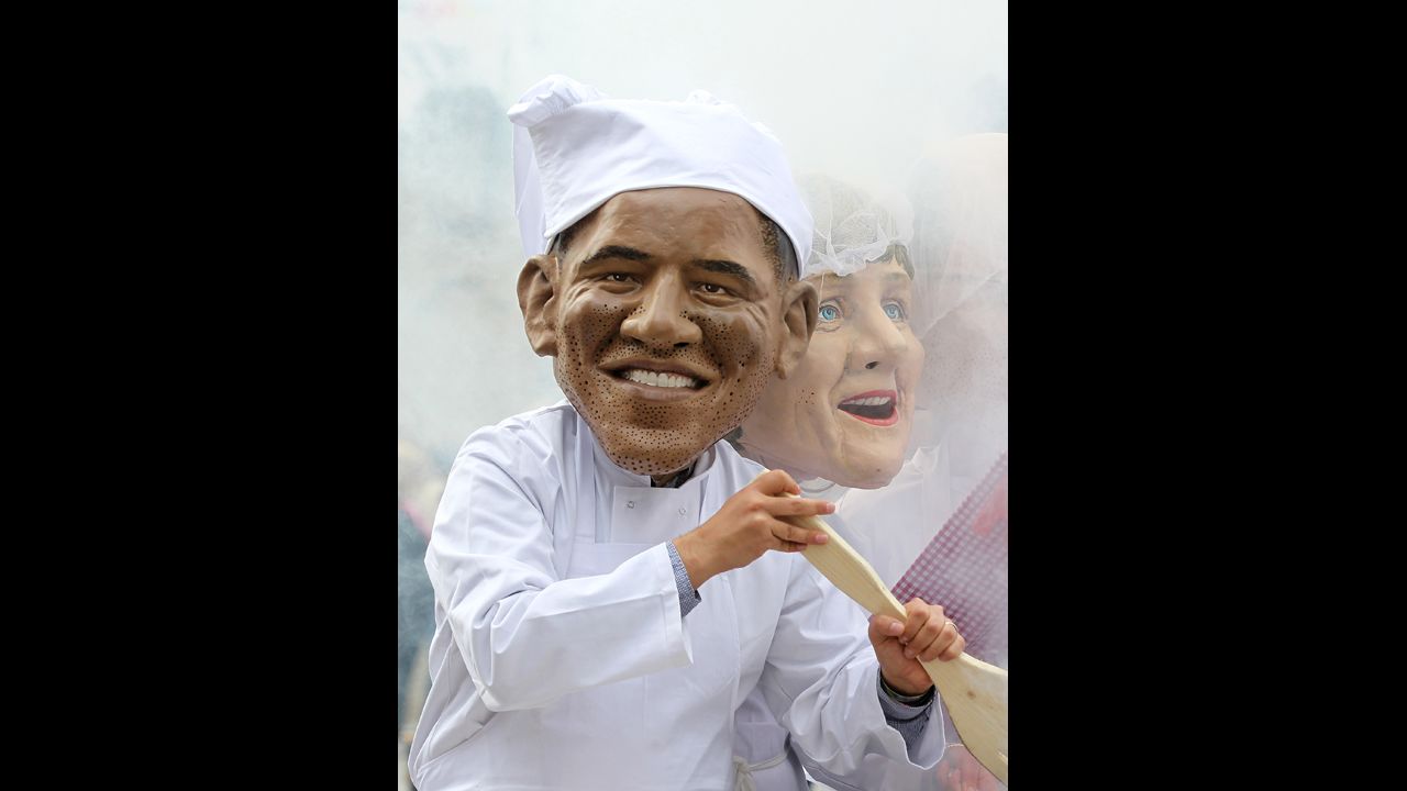 An Oxfam charity volunteer wearing an Obama head stirs a cauldron on June 16.