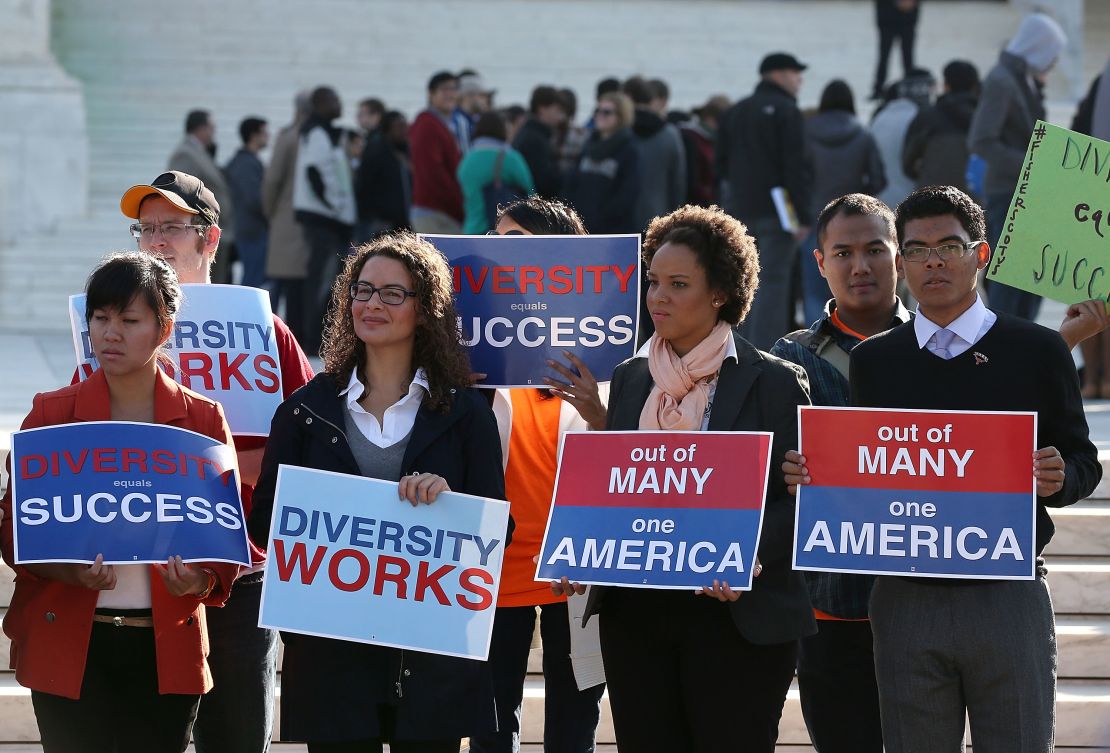 Protesters supporting diversity in college admissions hold signs in front of the US Supreme Court on October 10, 2012, in Washington. 