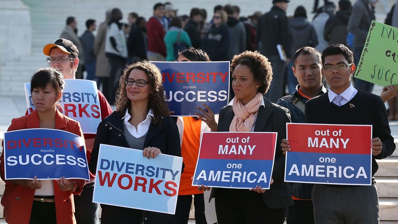 Protesters hold signs in front of the US Supreme Court on October 10, 2012 in Washington.