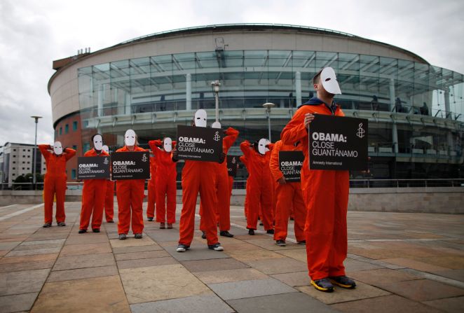 Amnesty International volunteers demonstrate outside the Waterfront Hall in Belfast on June 16 in masks and orange suits depicting detainees at Guantanamo Bay.