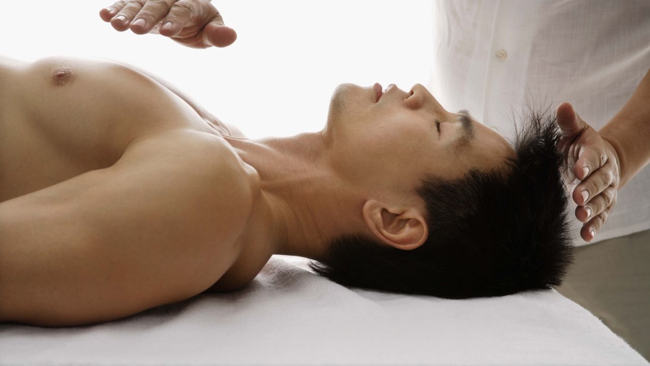 A man receives a reiki treatment. While alternative therapies can be valuable, some cross the line, according to Dr. Paul Offit. 