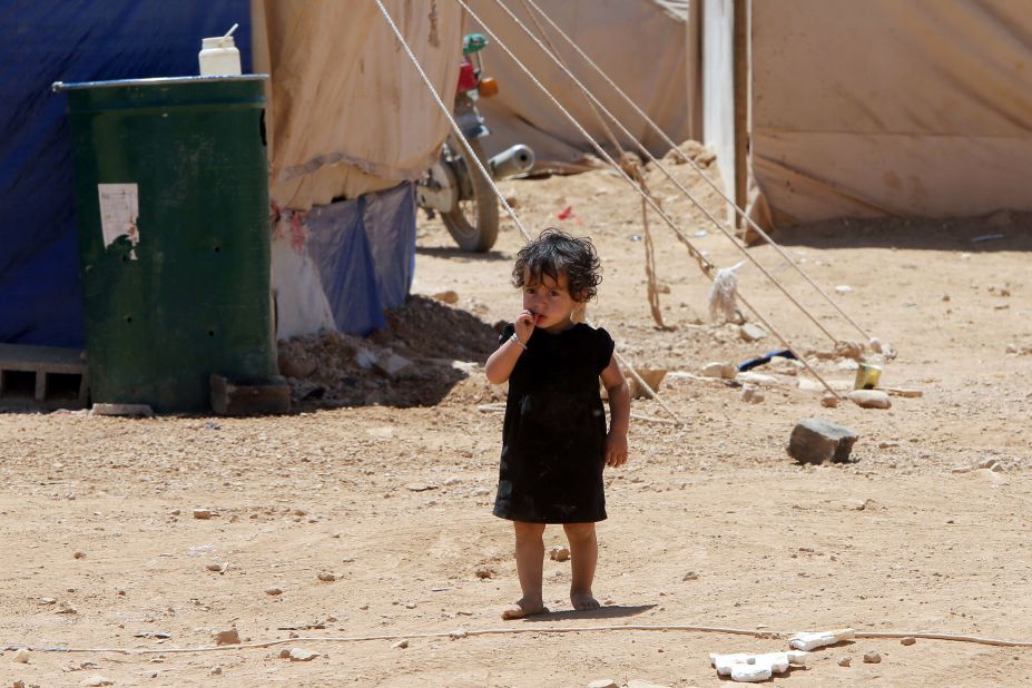 A child whose family fled violence in Syria stands at the Arsal refugee camp in Lebanon in June 2013.