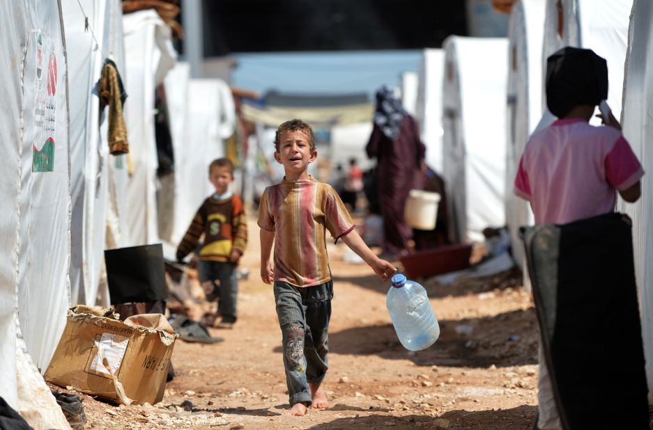 A boy carries a jug for water at the Maliber al-Salam refugee camp in April 2013. The camp, near the Turkish border, houses internally displaced Syrian families.