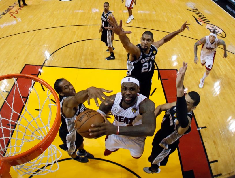 LeBron James of the Miami Heat goes up for a shot against Kawhi Leonard, left, Tim Duncan and Danny Green, right, of the San Antonio Spurs in the first half.