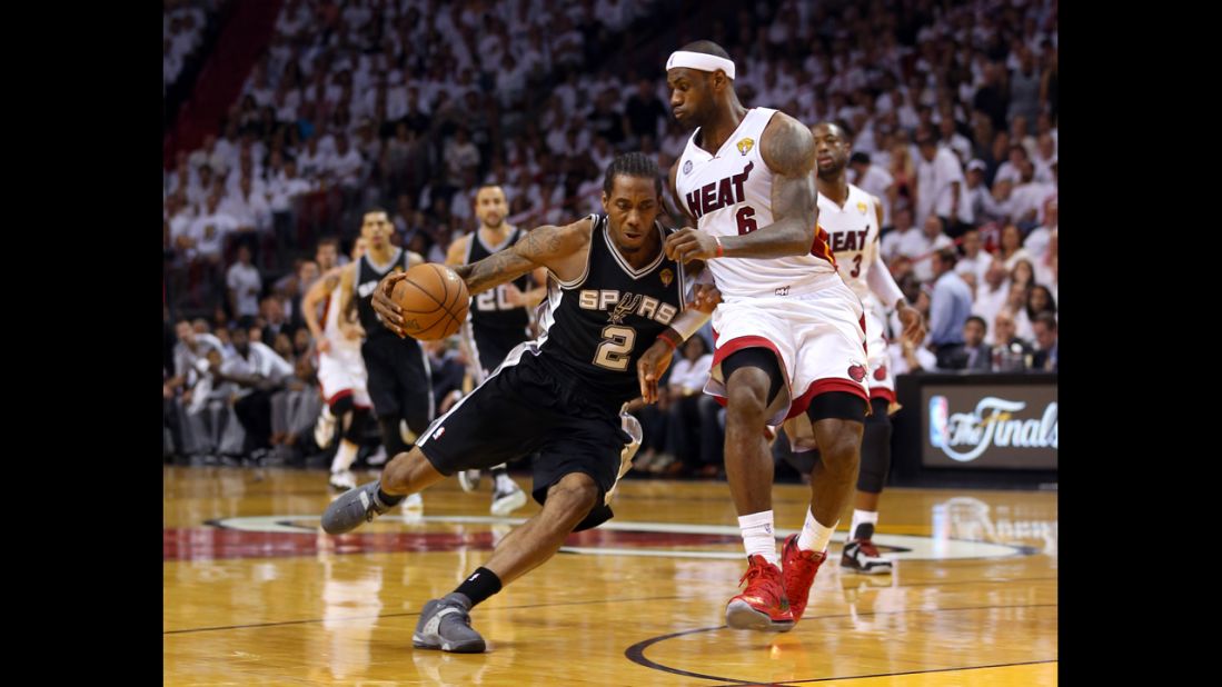 Kawhi Leonard of the San Antonio Spurs drives on LeBron James of the Miami Heat in the first quarter.