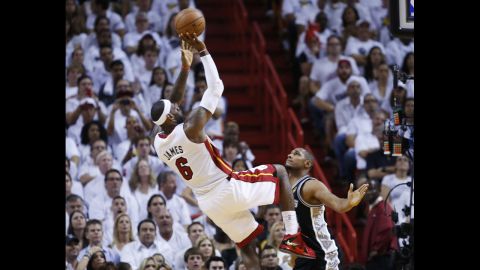 Miami Heat's LeBron James takes a fade-away jumper while being guarded by San Antonio Spurs' Boris Diaw.