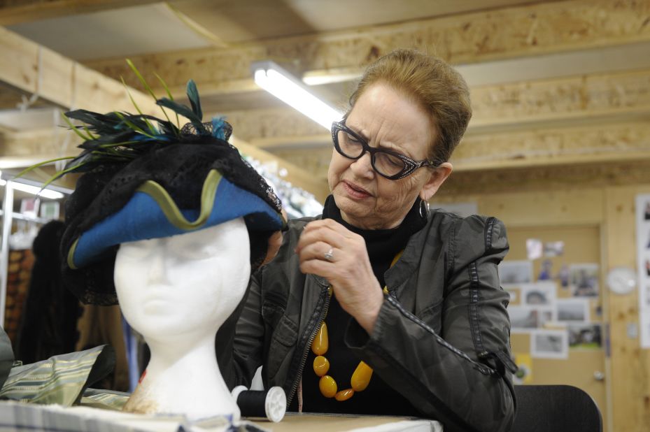 White works on a hat for Elizabeth. "I fall in love with every garment as its being made," she said.
