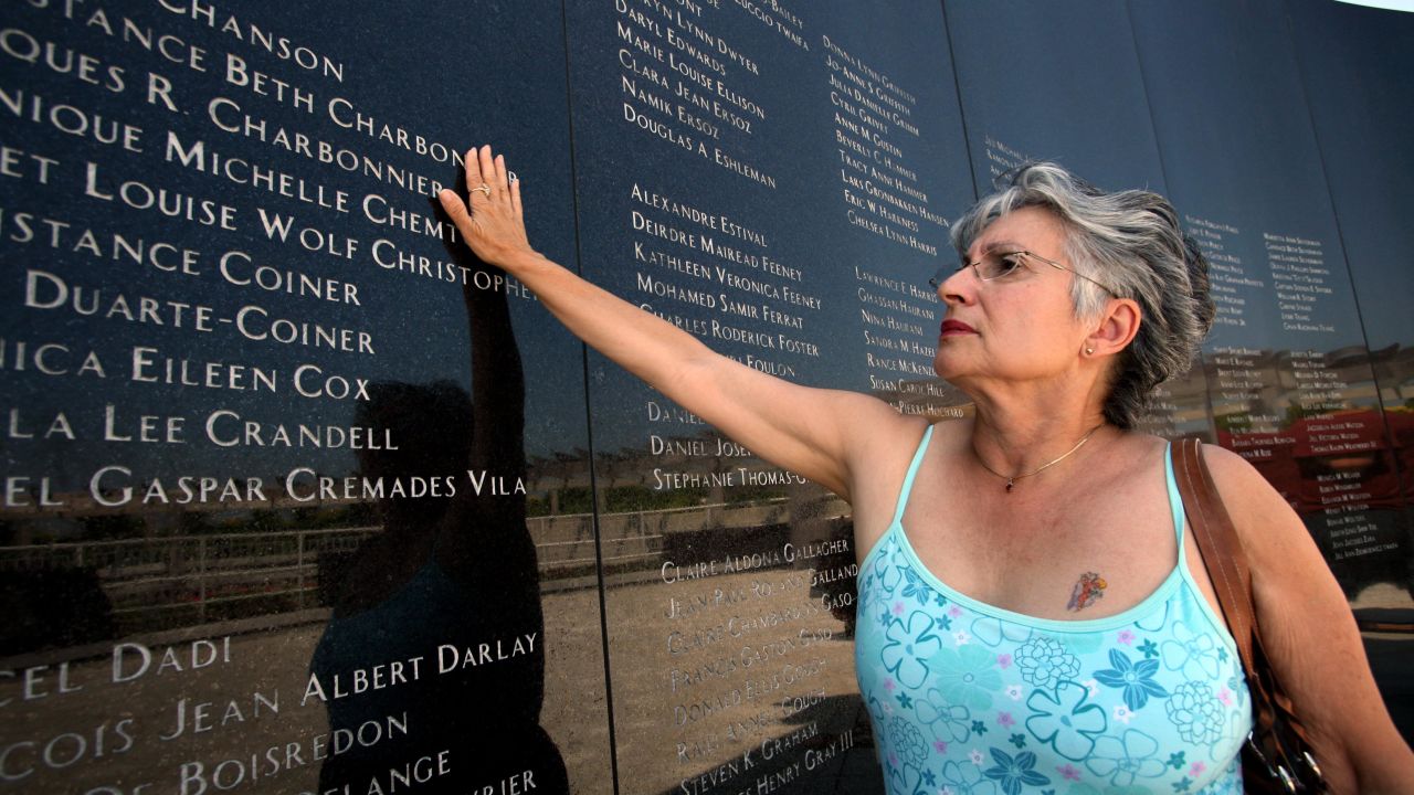 Joanne Festa touches the memorial wall commemorating the victims of TWA Flight 800 on July 16, 2006, at the Smith Point County Park in Shirley, New York.