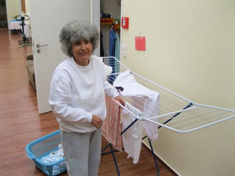 Martha Hütter, a resident at the shared apartment in Potsdam, hangs out the washing. Residents suffer from dementia, but everyone is encouraged to contribute to the household chores.