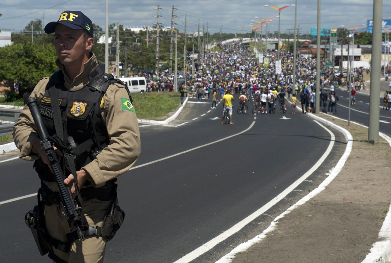 A police officer holds his weapon as protesters continue their demonstration ahead of Brazil's Group A match with Mexico in the ongoing Confederations Cup.