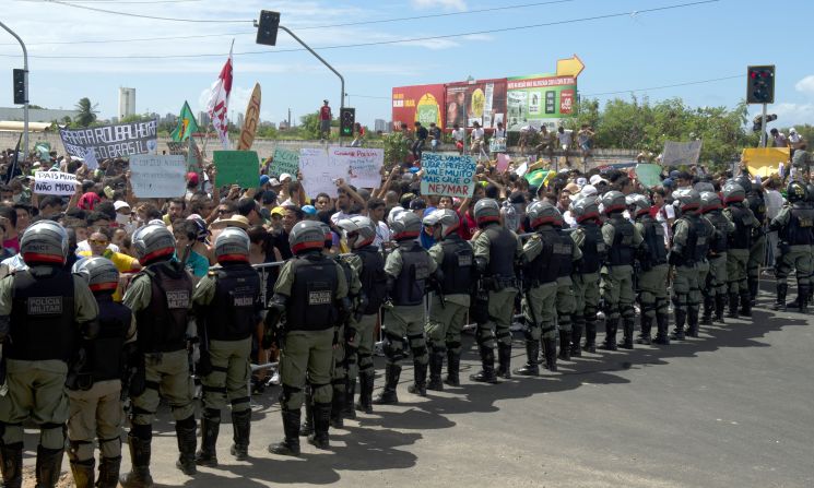 Protesters confront riot police officers on the distant outskirts of the Castelao Stadium, which has been newly built for next year's World Cup at a cost of $240 million.