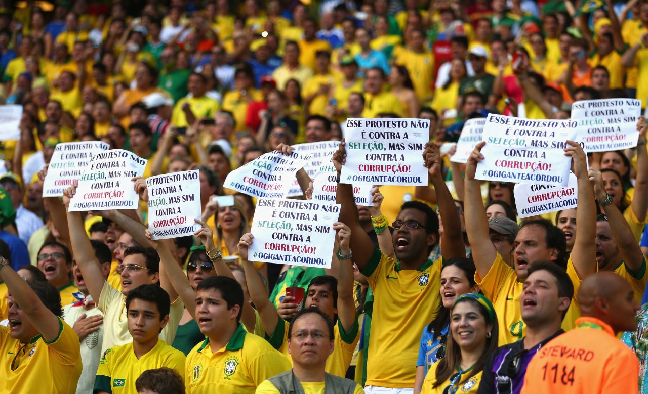 Fans hold up banners - which state that they are protesting against corruption, rather than the national team - ahead of Brazil's 2-0 win over Mexico.