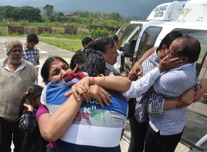 Evacuees hug their family members after arriving by helicopter in Dehradun, the capital of the state of Uttarakhand on June 19.