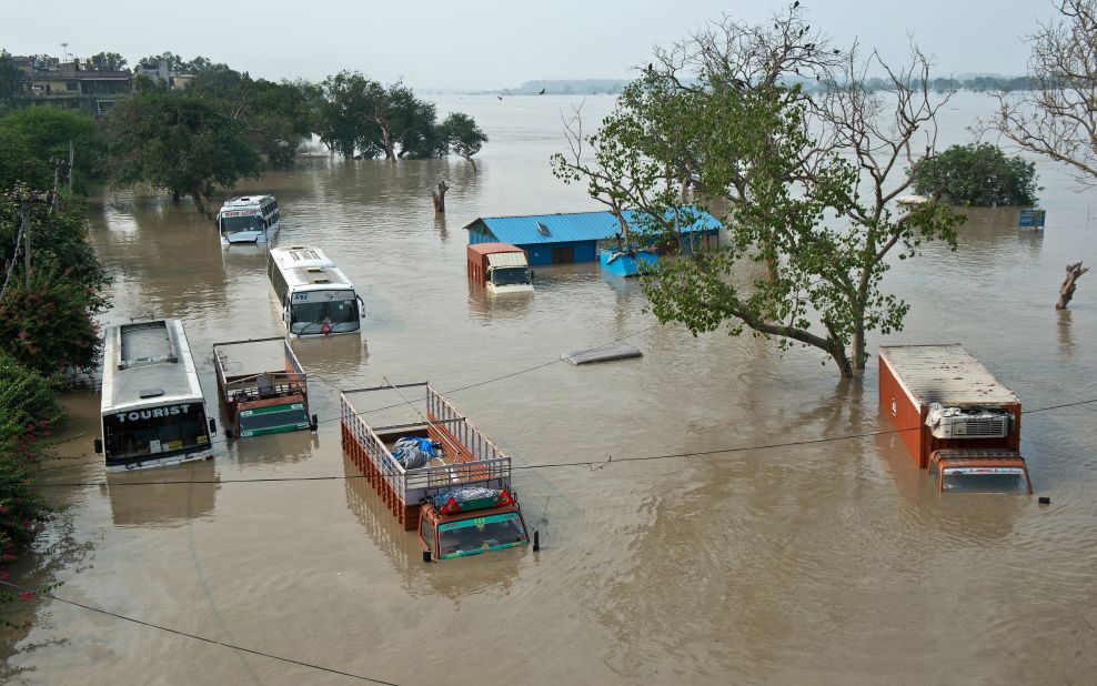 Buses and trucks are submerged in the rising waters of the Yamuna River near the Tibetan market in New Delhi on June 19.