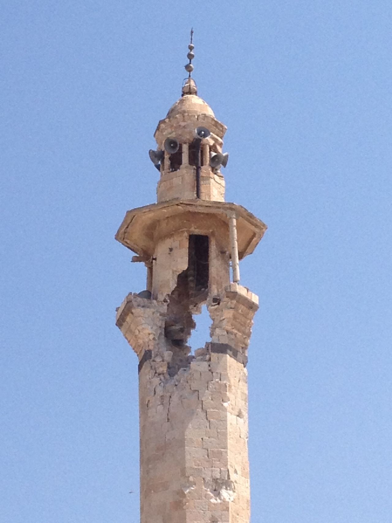 The mosque's minaret has a gaping hole after being hit by a shell.