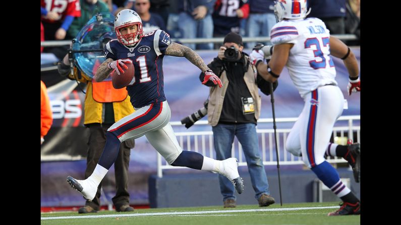 Hernandez scores a touchdown against the defense of George Wilson of the Buffalo Bills on January 1, 2012, in Foxborough, Massachusetts.