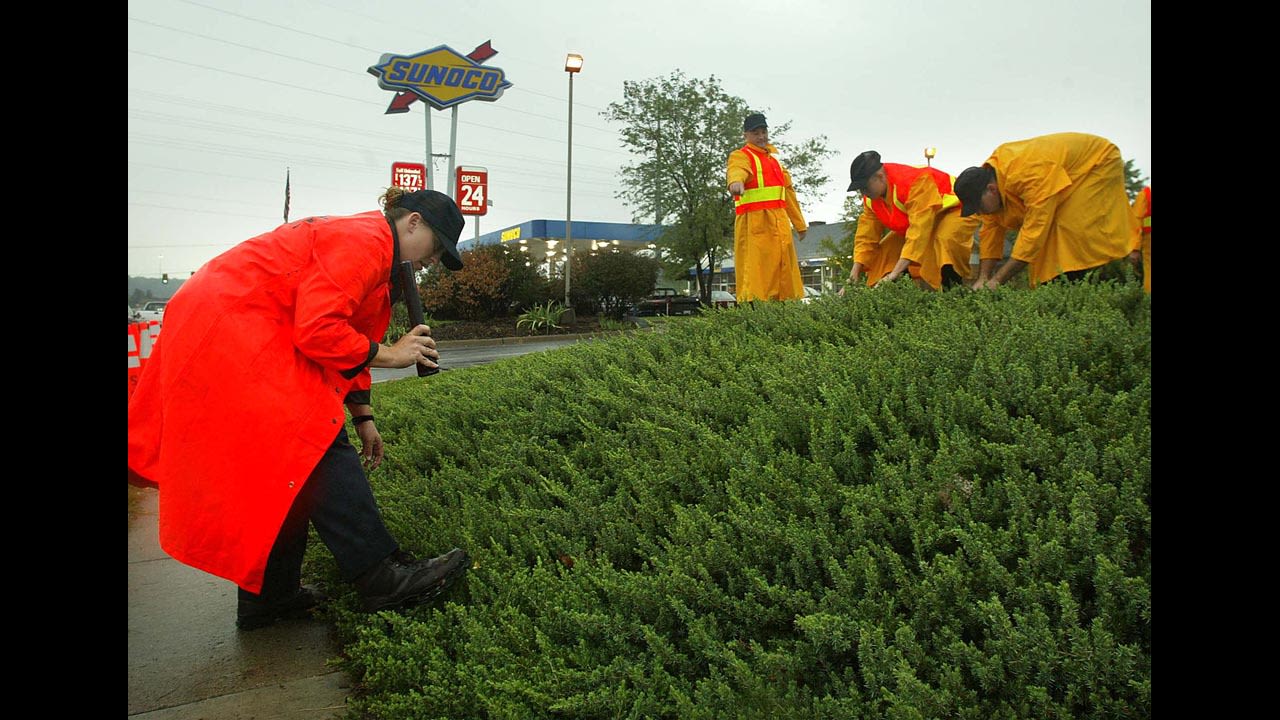 Police search the grounds near a Sunoco gas station in Manassas, Virginia, where Dean Harold Meyers, 53, was shot and killed on October 10, 2002. 
