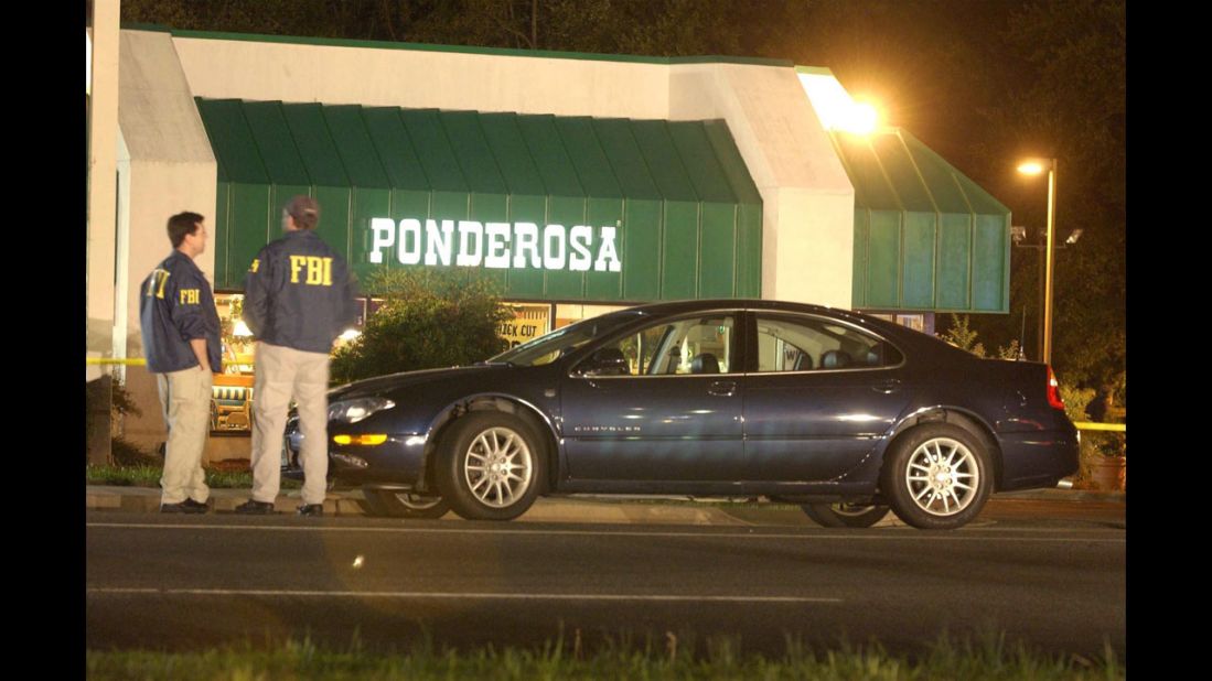 Two FBI agents stand in front of a Ponderosa restaurant in Ashland, Virginia, where Jeffrey Hopper was shot on October 19, 2002. The 37-year-old was shot in the stomach while walking with his wife in the parking lot. He survived.