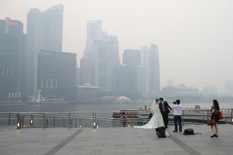 Undeterred by the smog, a couple took engagement photographs in front of the city's skyline at the Marina Bay waterfront on June 20.