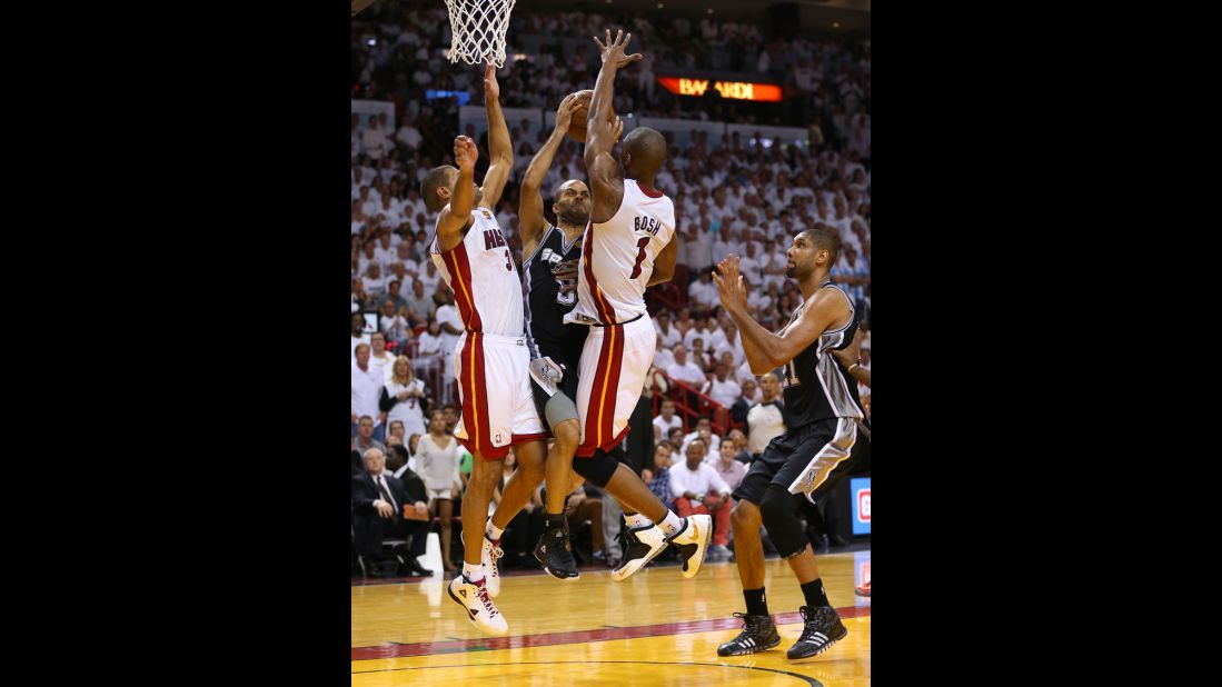 Tony Parker of the San Antonio Spurs drives on Shane Battier and Chris Bosh of the Miami Heat in the fourth quarter.