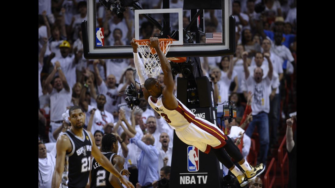 Dwyane Wade of the Miami Heat hangs from the basket after a dunk.