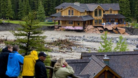 Residents watch as floodwaters from Cougar Creek destroy a neighborhood in Canmore, Alberta, on Thursday, June 20. 