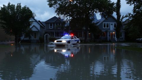 A police car patrols a flooded Calgary neighborhood that was evacuated on June 20.