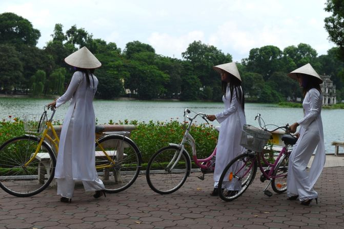 <strong>Hoan Kiem Lake: </strong>Young girls wear traditional conical hats and "ao dai" dresses in honor of a celebration at Hoan Kiem Lake, a popular hangout for locals. The lake is a stop during the eBuddies half-day tour. 
