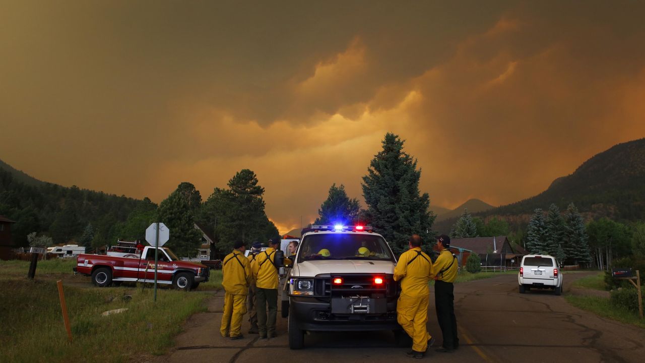 Firefighters monitor a wildfire in a residential area in South Fork on Friday, June 21.