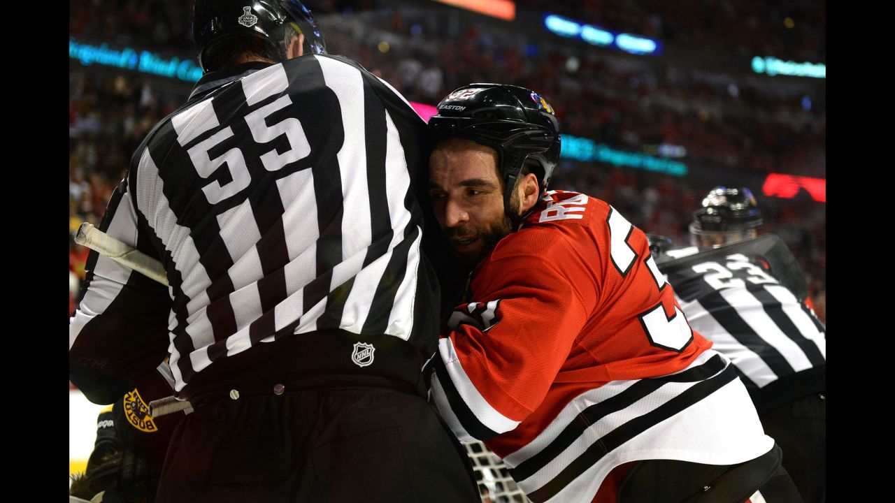 Michal Rozsival of the Chicago Blackhawks is pushed into linesman Shane Heye.