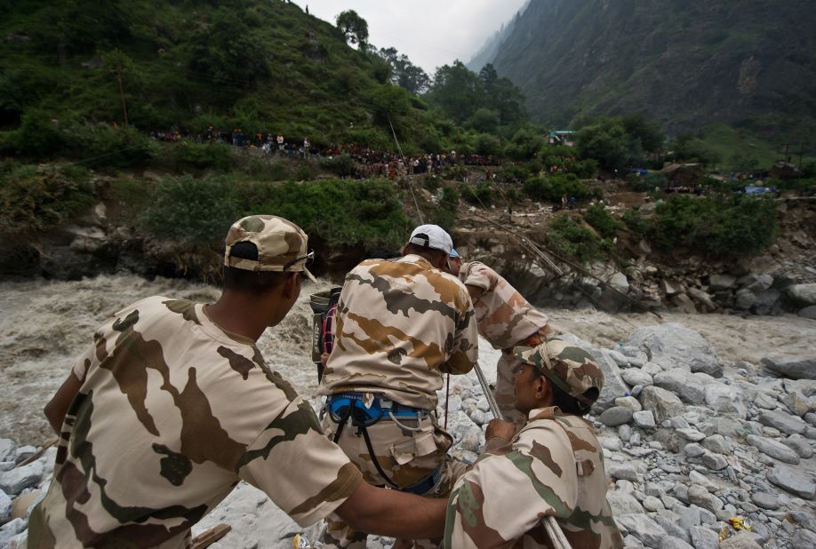 Police personnel use a rope rescue system to transport stranded pilgrims across a river in Govindghat on June 23.