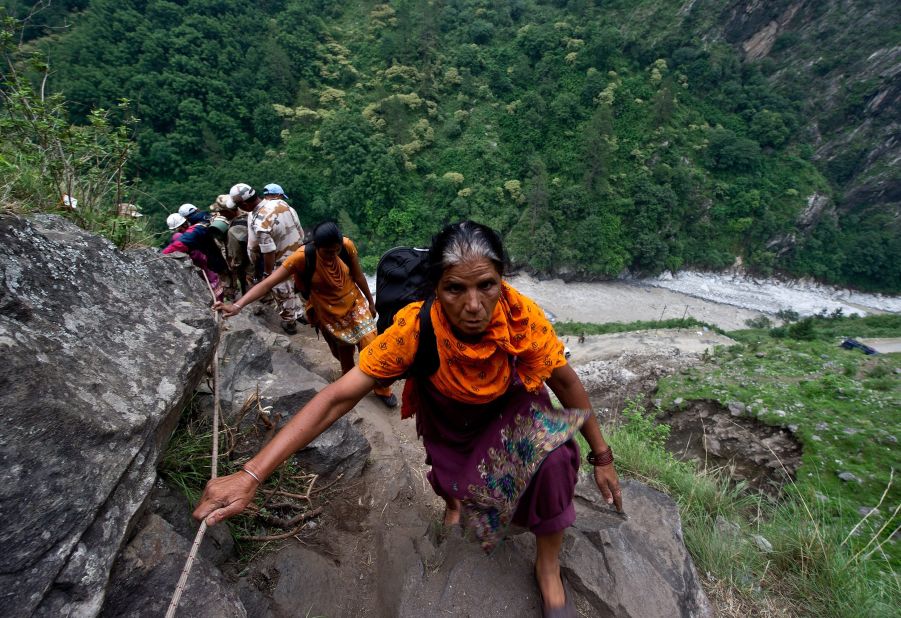 Stranded Indian pilgrims make their way up a mountain in Govindghat on June 23.