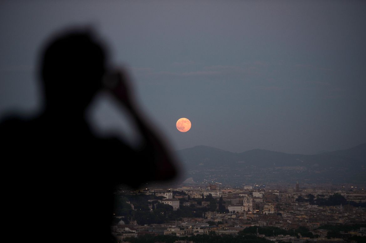 Onlookers view the full moon over the city of Rome on June 23.