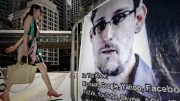 A woman walks past a banner displayed in support of former US spy Edward Snowden in Hong Kong on June 18, 2013. 