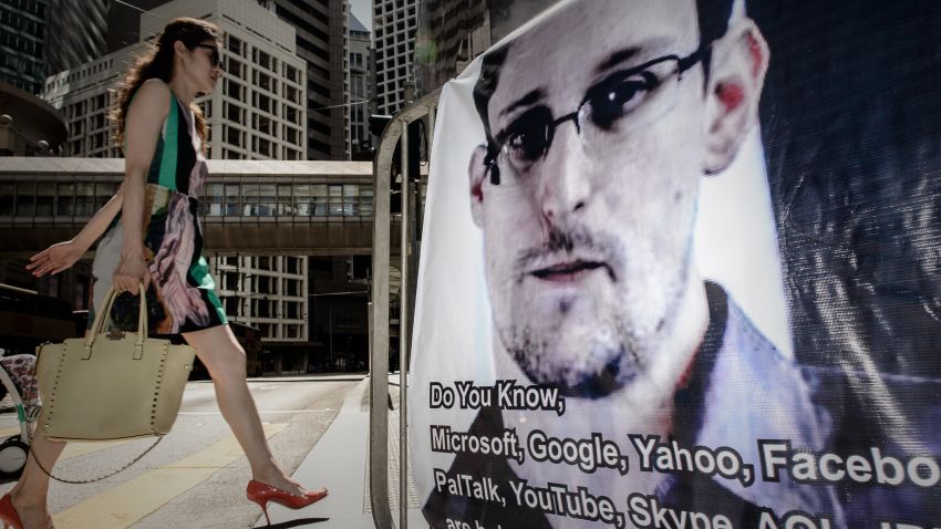 A woman walks past a banner displayed in support of former US spy Edward Snowden in Hong Kong on June 18, 2013.
