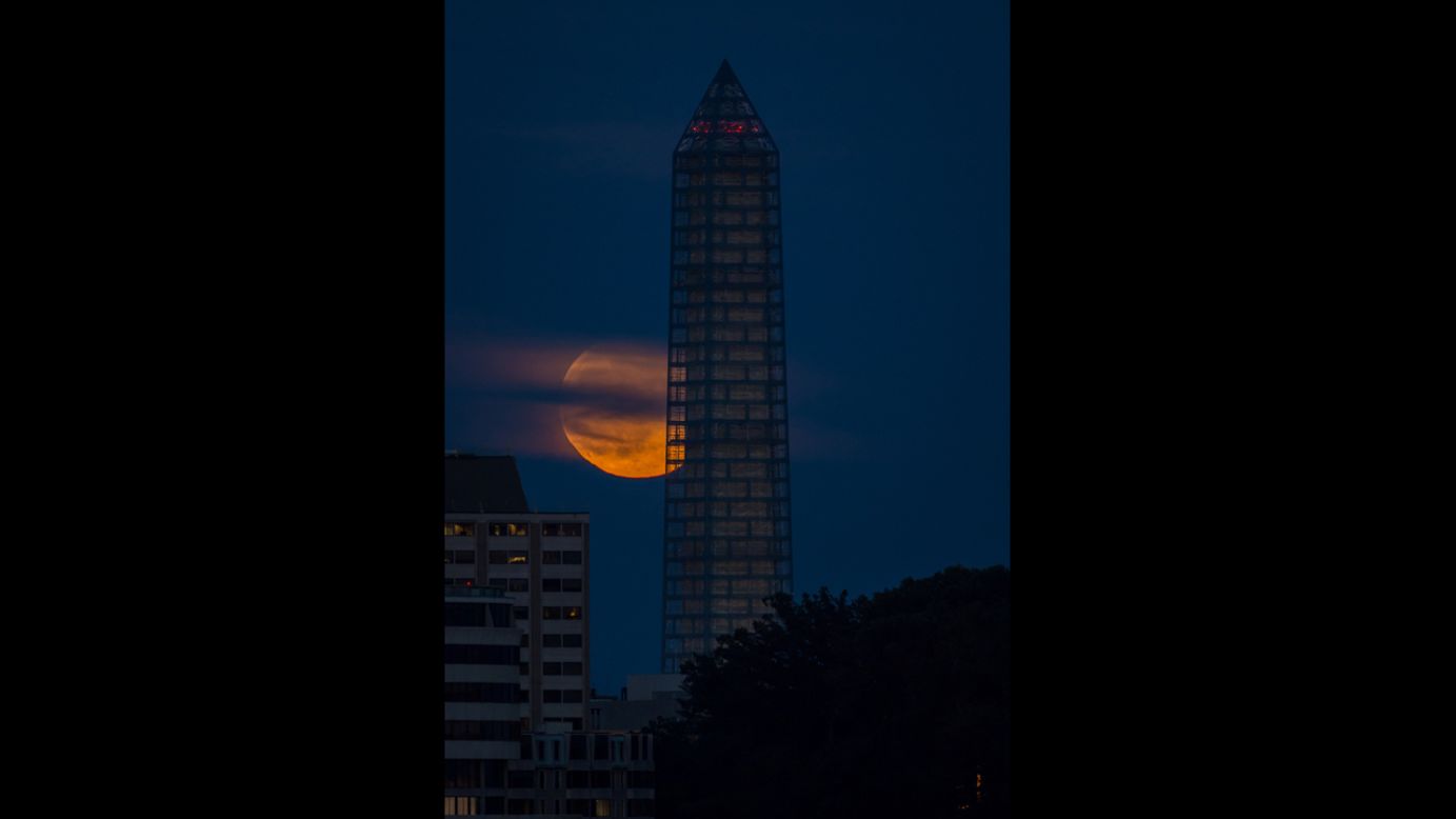 The moon rises behind the Washington Monument on June 23.