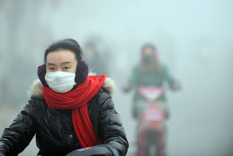 A woman rides a bike in the heavy smog with a mask on a street in central China's Anhui province in January 2013. Greenpeace released a 2013 report claiming that 83,500 people died prematurely in 2011 from respiratory diseases in Shandong, Inner Mongolia and Shanxi -- China's top three coal-consuming provinces.