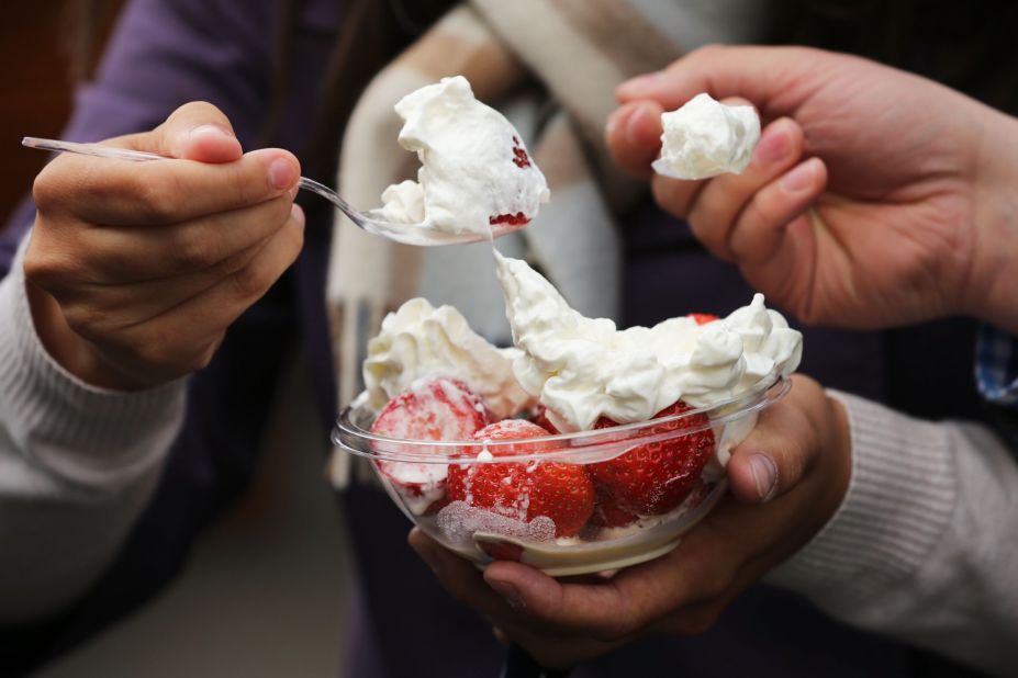 Spectators enjoy a bowl of strawberries and cream on June 24 during Wimbledon at the All England Lawn Tennis and Croquet Club in London.