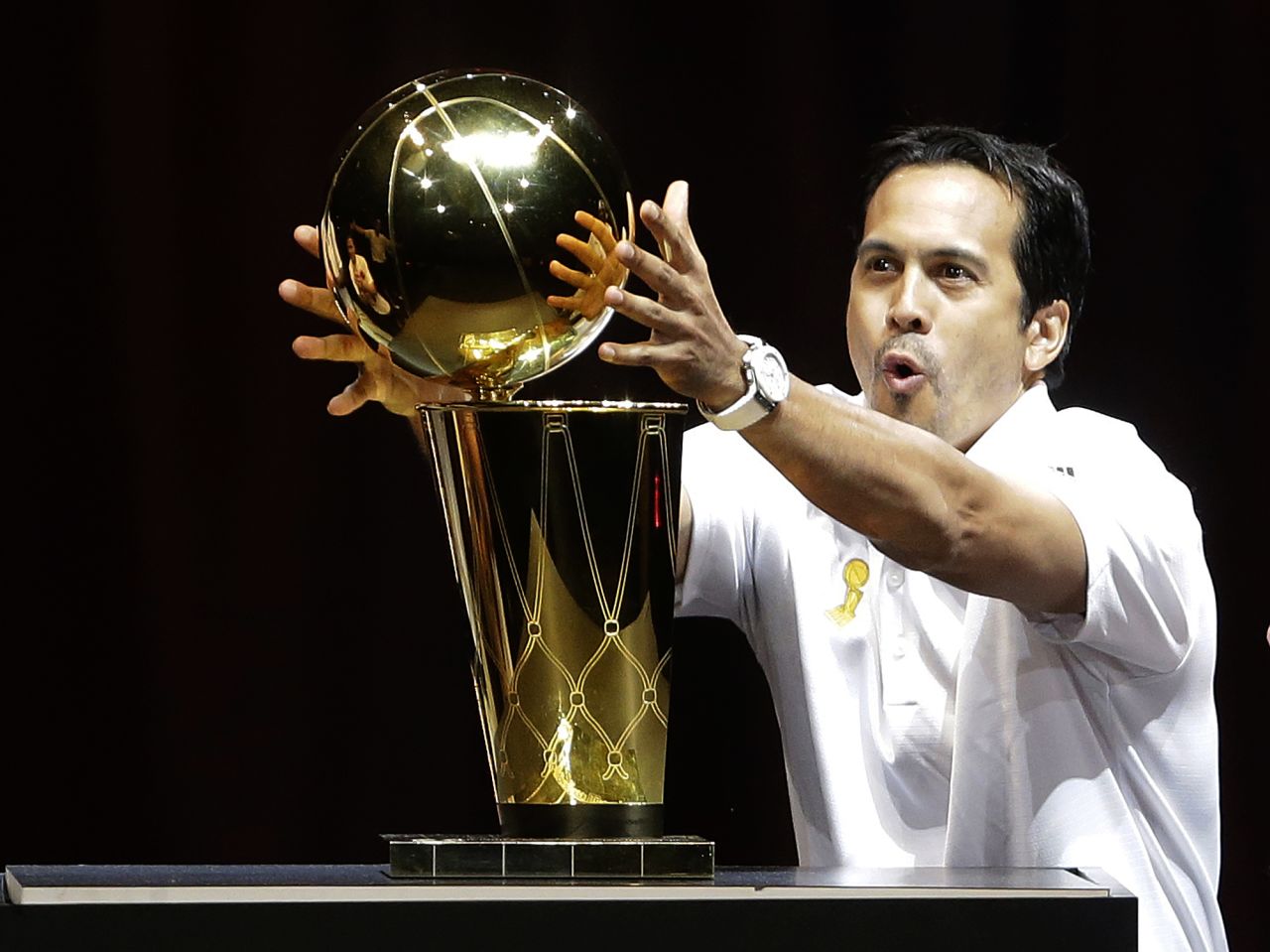 Miami head coach Erik Spoelstra reaches out to touch the Larry O'Brien NBA Championship trophy.