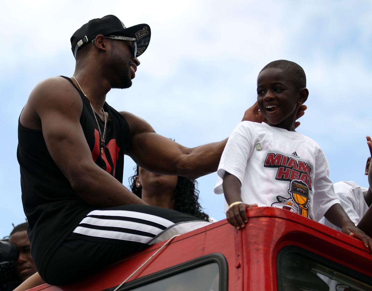 Dwyane Wade and his son ride in the parade.