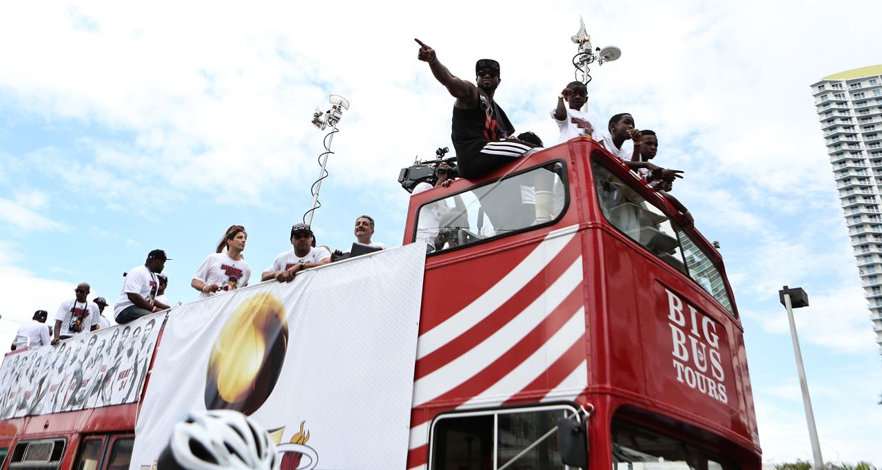Dwyane Wade acknowledges the crowd from the top of a double-decker bus.