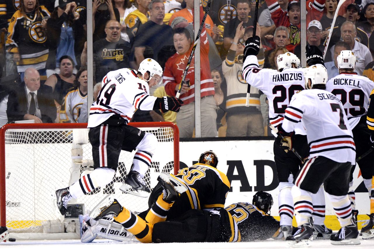 Jonathan Toews of Chicago, left, celebrates after scoring a goal against Boston.
