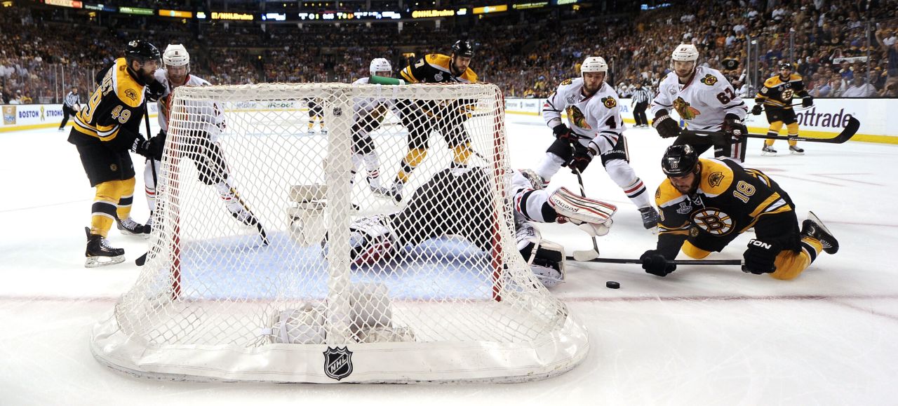 Goaltender Corey Crawford of the Chicago Blackhawks makes a save against No. 18 Nathan Horton of the Boston Bruins.