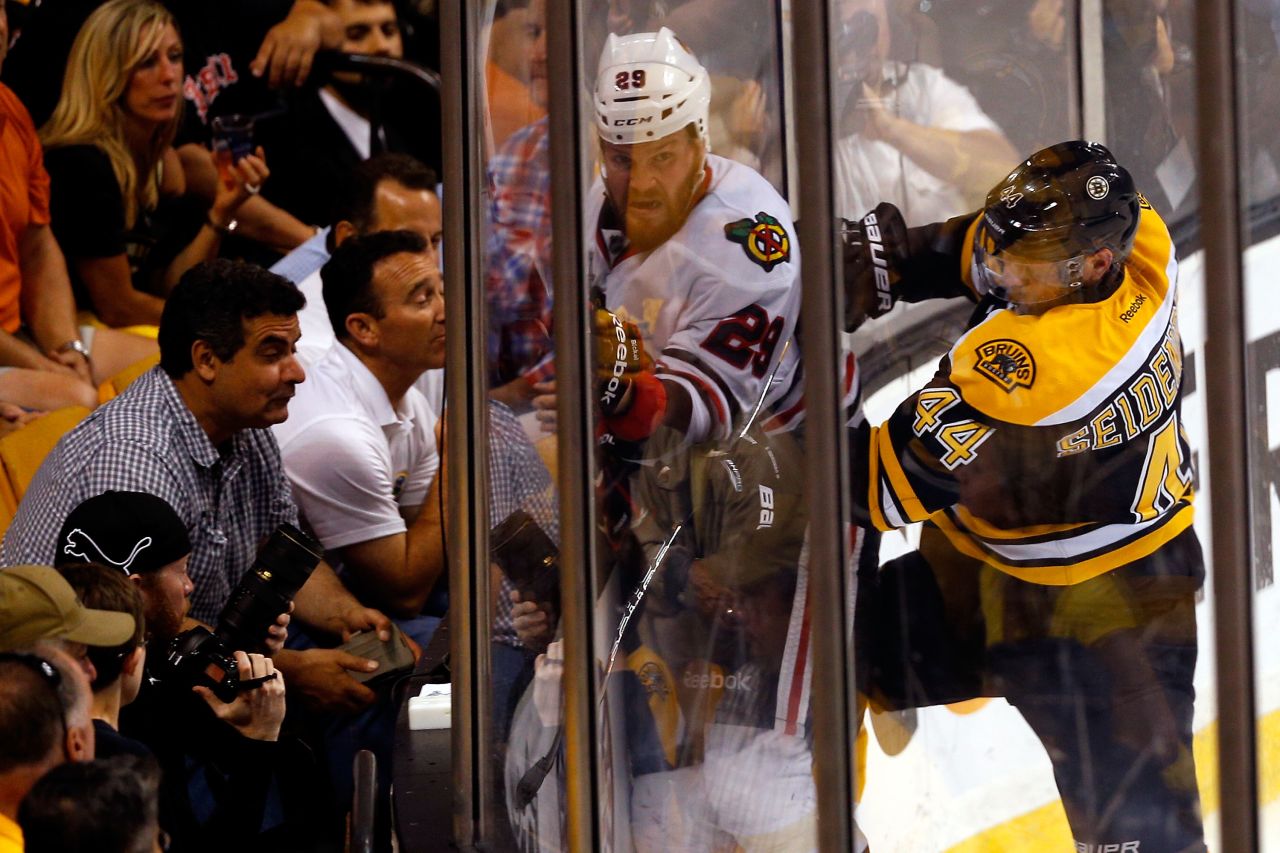 Dennis Seidenberg of the Boston Bruins checks Bryan Bickell of the Chicago Blackhawks.