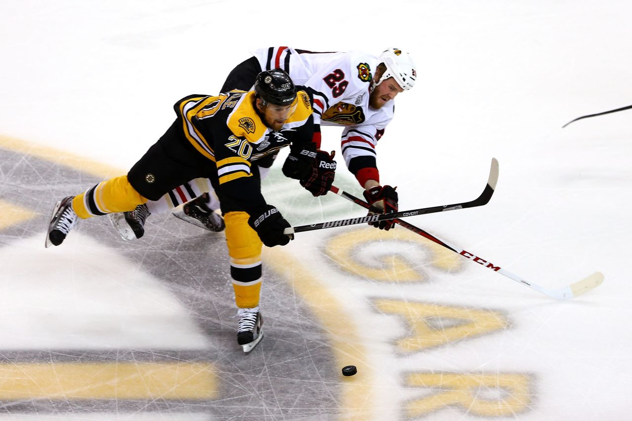 Daniel Paille of the Boston Bruins skates for the puck against Bryan Bickell of the Chicago Blackhawks.