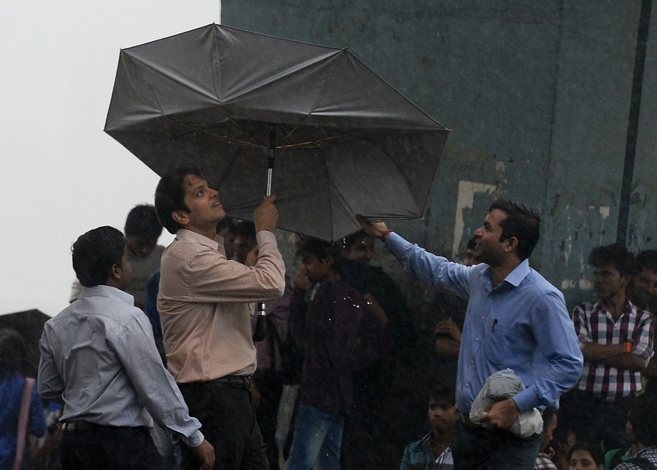 A man struggles with his umbrella during heavy rain in Mumbai on June 24.